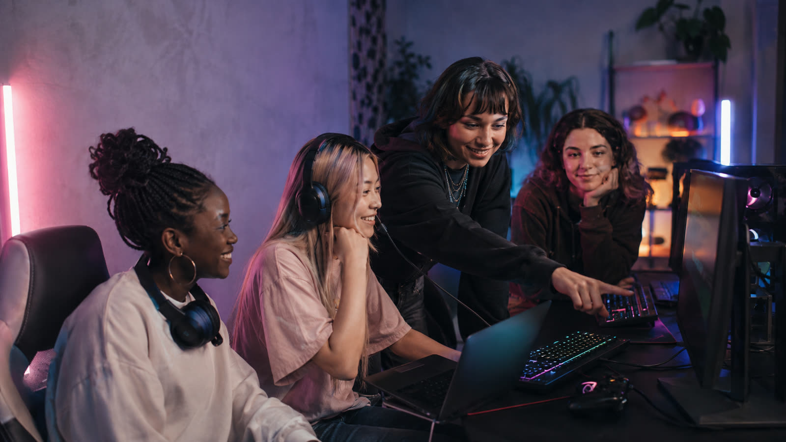 Gamerin coacht eine Mitspielerin am Bildschirm
