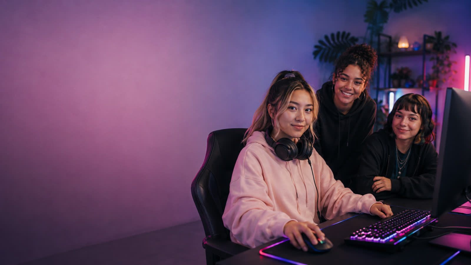 Drei Gamerinnen an einem Gaming-PC mit RGB-Setup