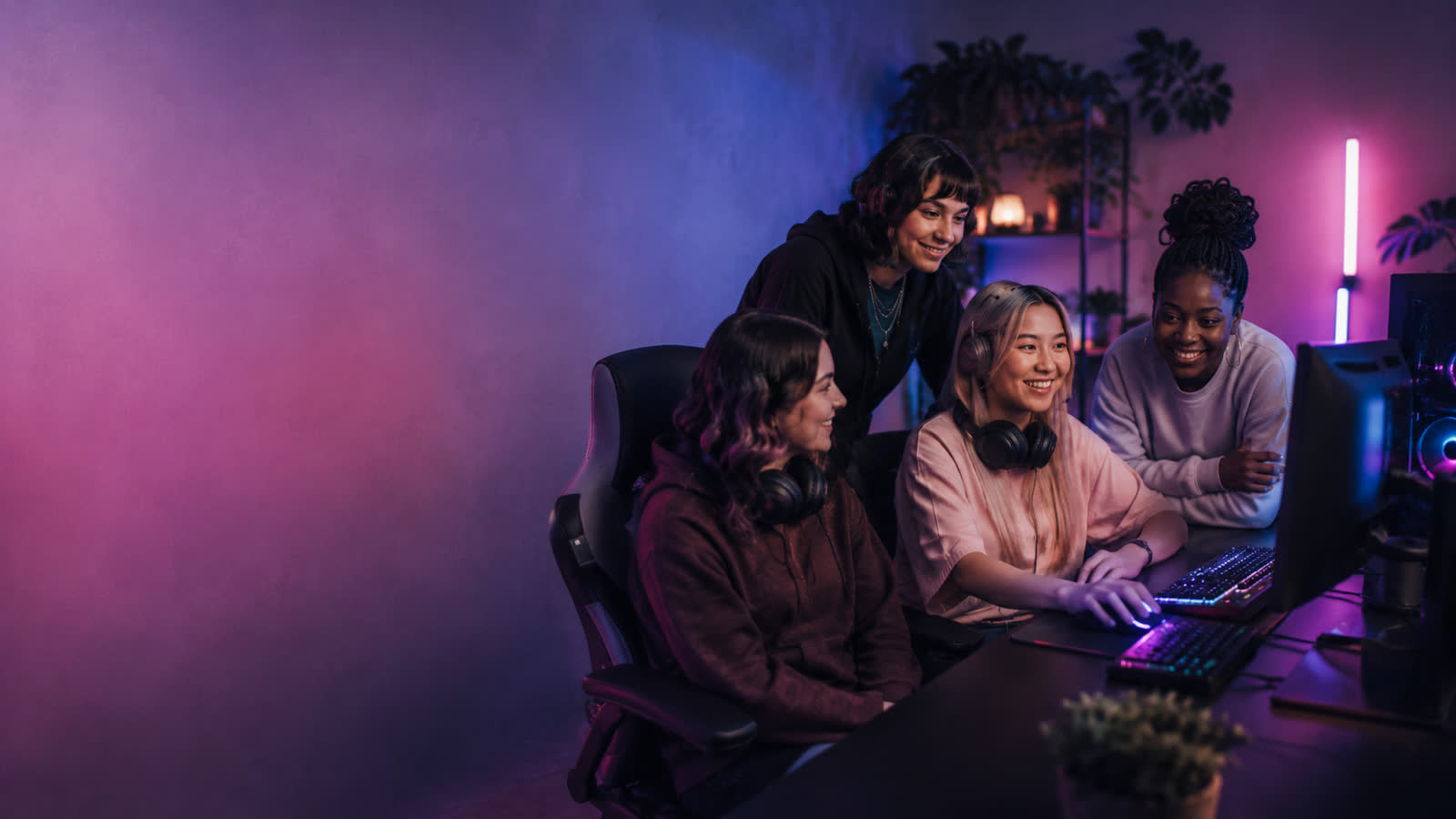 Vier Gamerinnen schauen gemeinsam auf einen Gaming-Monitor
